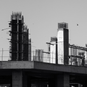 Pilares y vigas de hormigón de un edificio en construcción, fotografiados en blanco y negro.