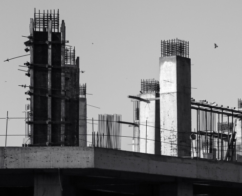 Pilares y vigas de hormigón de un edificio en construcción, fotografiados en blanco y negro.