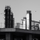 Pilares y vigas de hormigón de un edificio en construcción, fotografiados en blanco y negro.